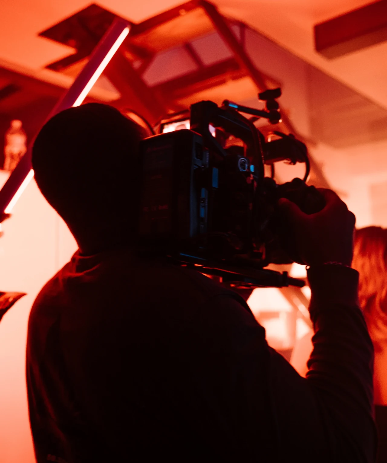 Camera operator working under orange production lighting